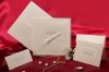  Esküvői meghívó - 170x170 mm - oldalra nyitható - külső lap: fehér mintával díszített pausz, fehér szalaggal, kivágással - betétlap: krémszínű matt papír