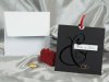       Esküvői meghívó - 150x150 mm - tasak: fekete matt karton, aranyozással, színtelen nyomással, ablakkal - betétlap: piros szaténszalaggal kihúzható
