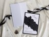  Esküvői meghívó - 120x170mm - tasak: fekete matt karton, fekete fólianyomással kivágással, ebbe helyezhető a fehér betétlap