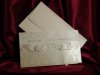 Esküvői meghívó - 230x130 mm - tasak: krémszínű karton, matt mintával, aranyozással, díszes kivágással - betétlap: arany gyöngyházfényű karton, dombornyomott mintával - boríték: krémszínű gyöngyházfényű papír